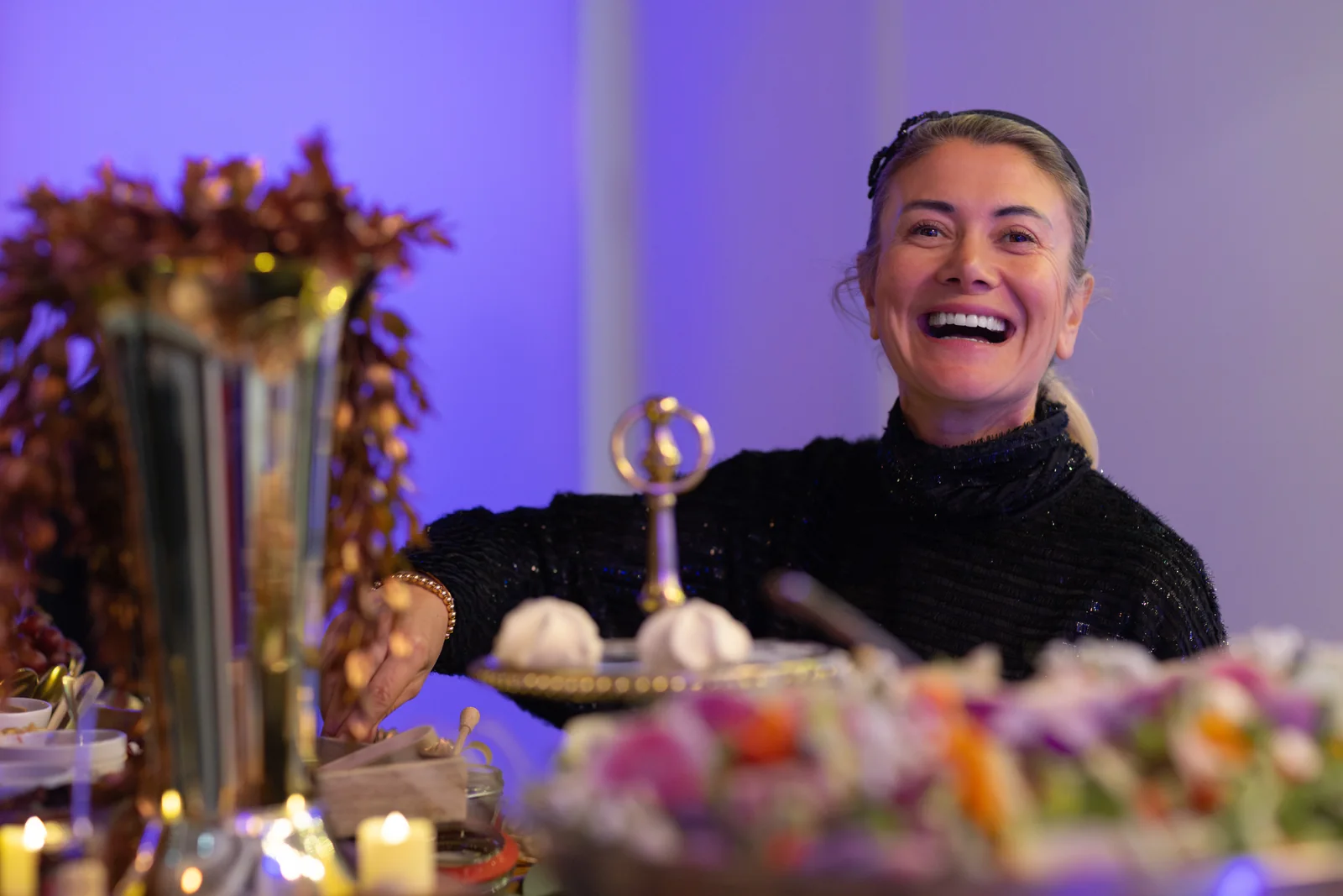 Zee smiling behind a beautifully set catering table
